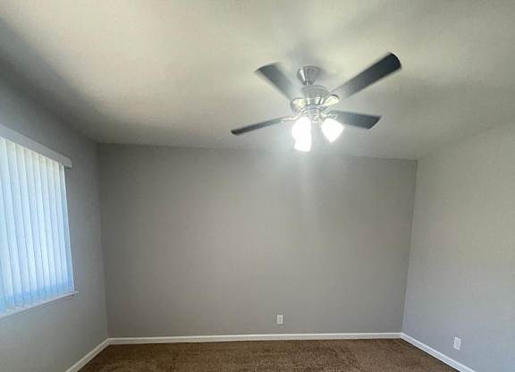 an empty room with a ceiling fan