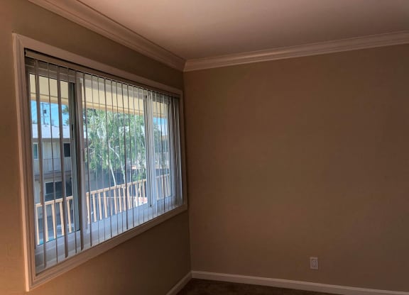 a living room with a large window with blinds