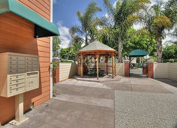 A parking lot with a wooden building and a gazebo.