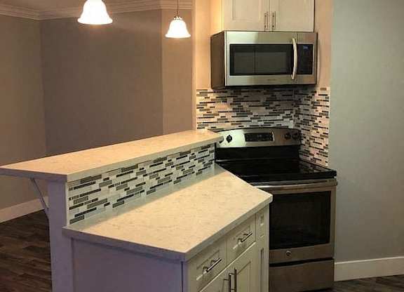 A kitchen with a stove top oven and a microwave above it.