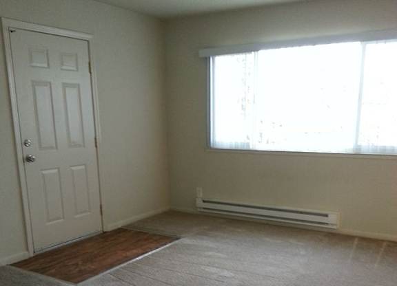 A room with a door, window, and a heater.