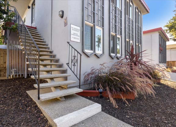 the front of a building with stairs and a yard