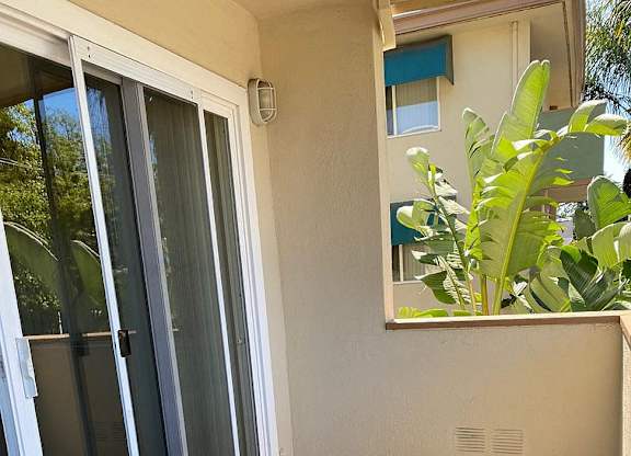 a balcony with a sliding glass door and a plant
