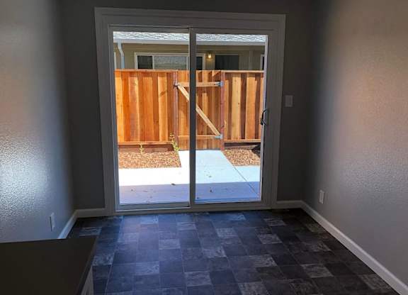 A room with a checkered floor and a door leading to a backyard.