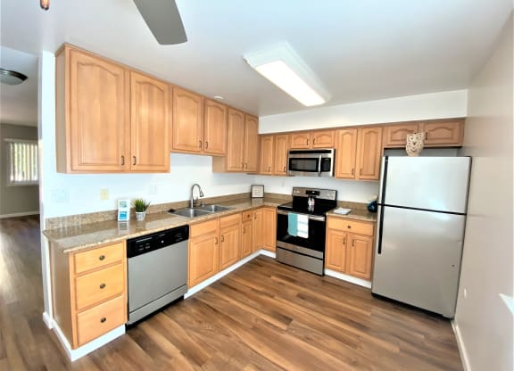 a kitchen with wooden cabinets and stainless steel appliances