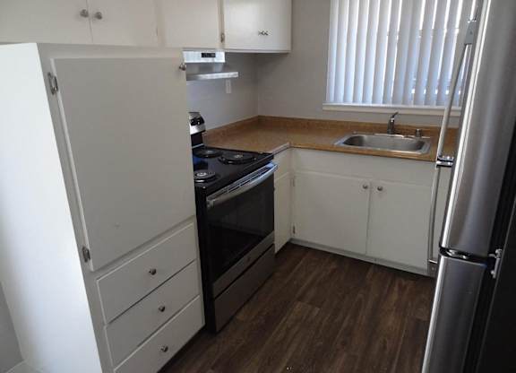 A kitchen with a black stove top oven and white cabinets.