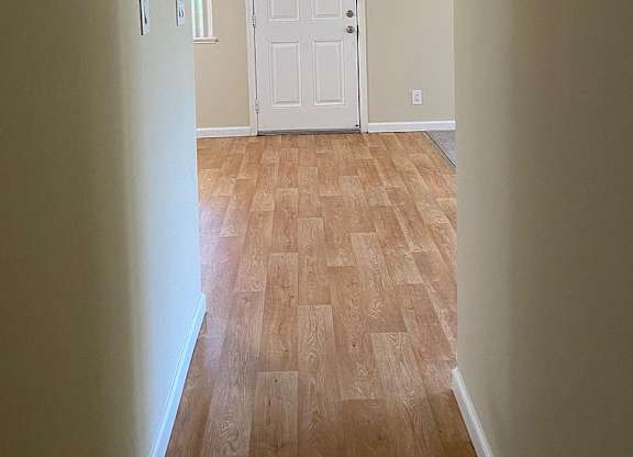 a empty room with a white door and a wooden floor
