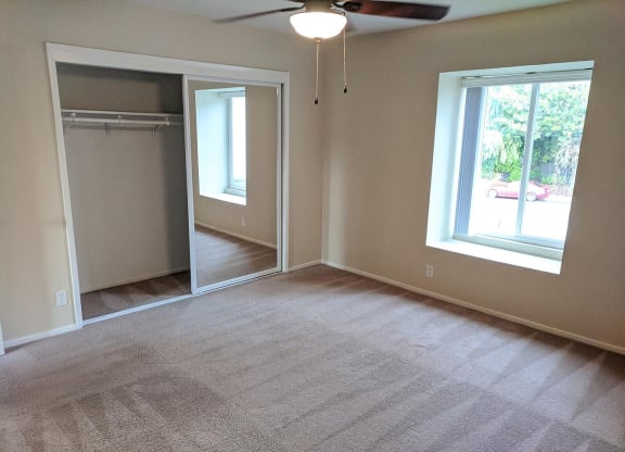 an empty living room with a closet and a window