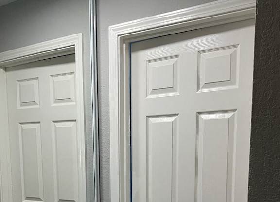 A white door with a gold handle is closed.