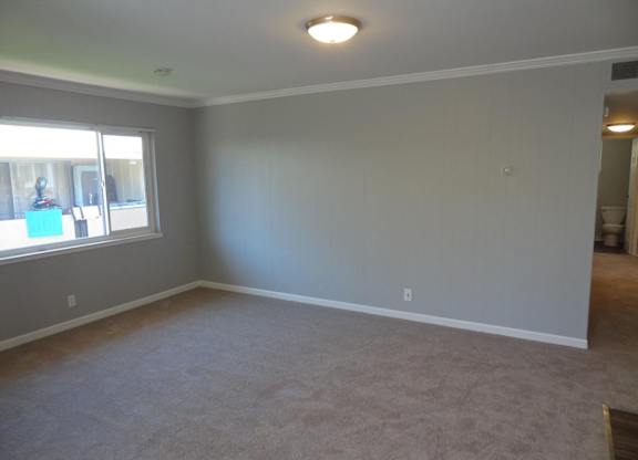 A room with a carpeted floor and a window.