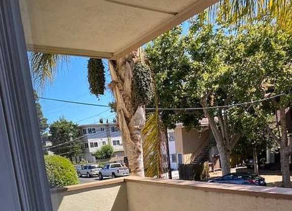 a balcony with a view of a street and trees