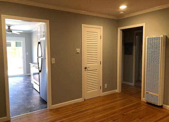 A room with a white door, a white wall, and a white ceiling.