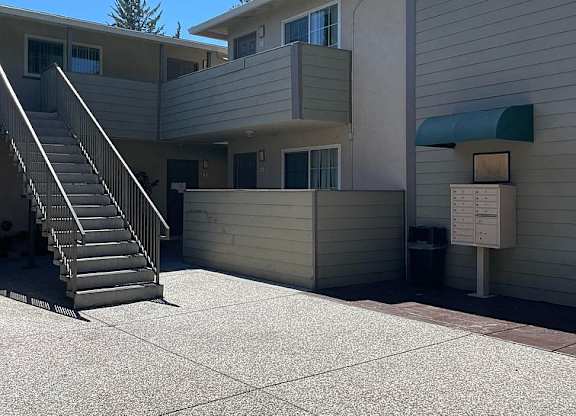 A concrete courtyard with a staircase leading to a building.