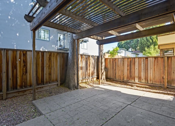 A patio with a roof and a concrete floor.