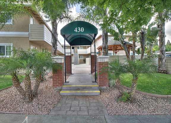 The entrance to apartment 430 is surrounded by trees and shrubbery.