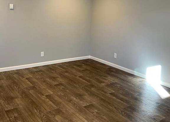 A room with wooden flooring and a light on the ceiling.