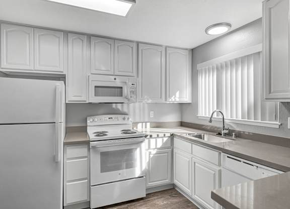 A kitchen with white appliances and cabinets.