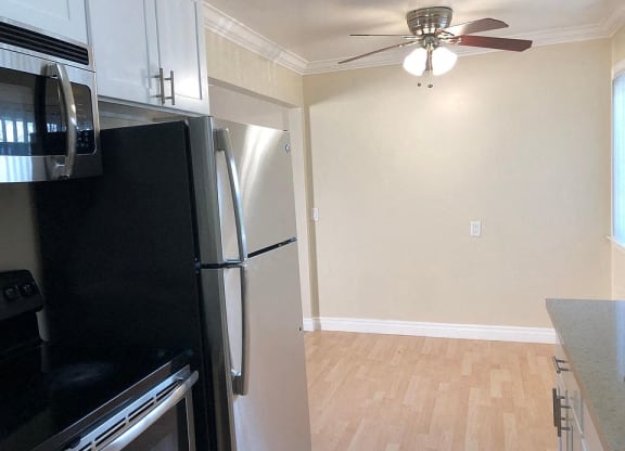 a kitchen with a refrigerator and a ceiling fan