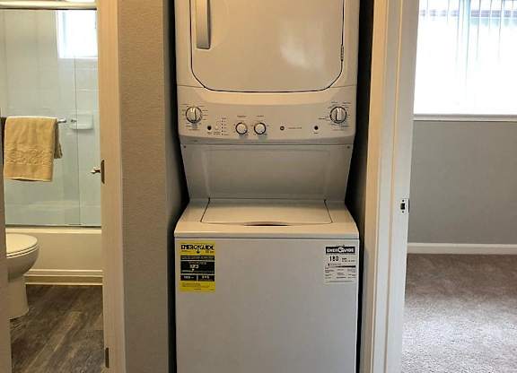 A white dryer is in a small closet.