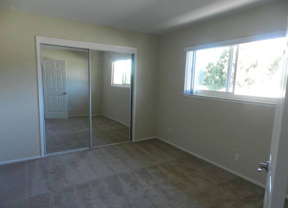 A room with a carpeted floor and a sliding glass door.