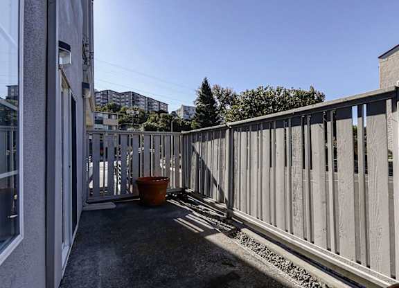 A balcony with a concrete floor and a metal railing.