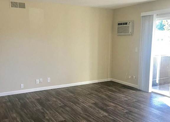A room with wood flooring and a window.