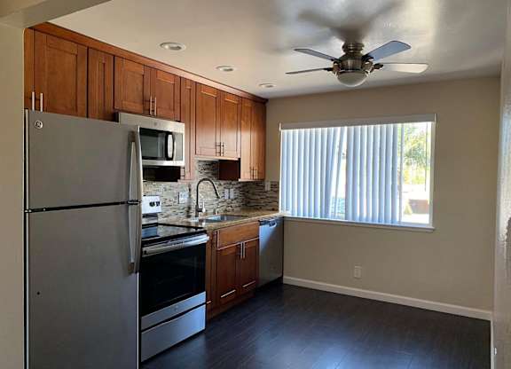 a kitchen with stainless steel appliances and a ceiling fan