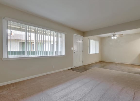 the living room and dining room of an empty home with a large window