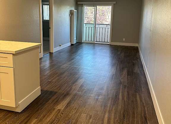 A long hallway with a fan and a window.
