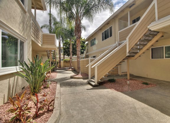 a building with stairs and palm trees in front of it