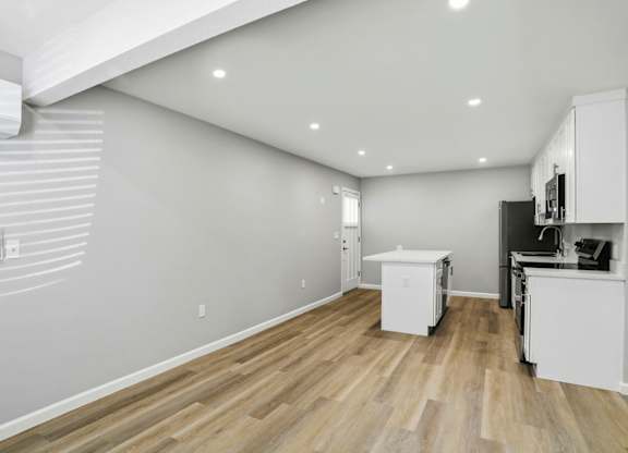 A kitchen with white cabinets and a white refrigerator.