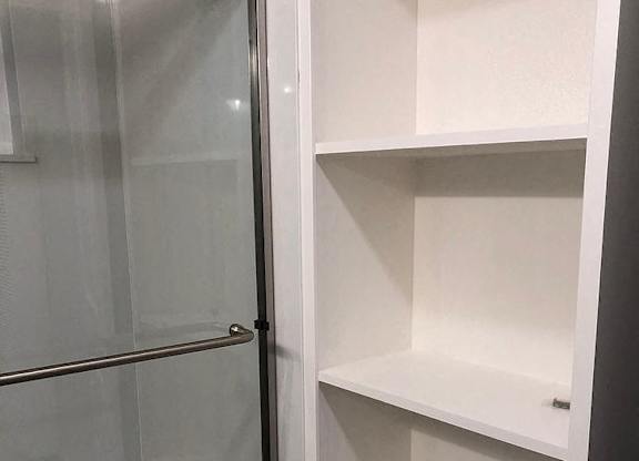 A white shelving unit with a glass door.
