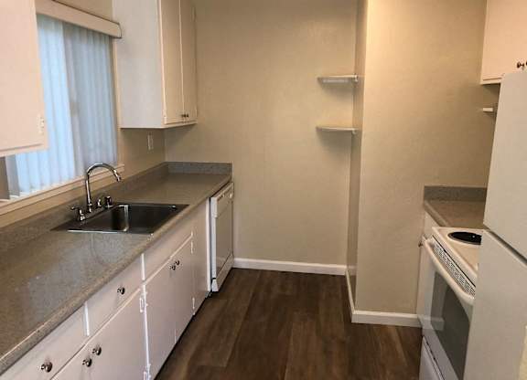A kitchen with white cabinets and a granite countertop.