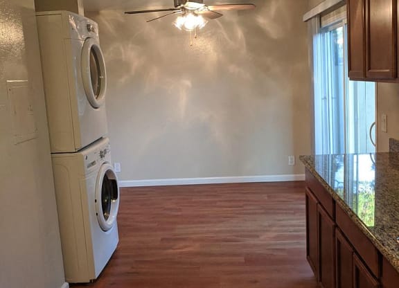a kitchen with a washing machine and a ceiling fan