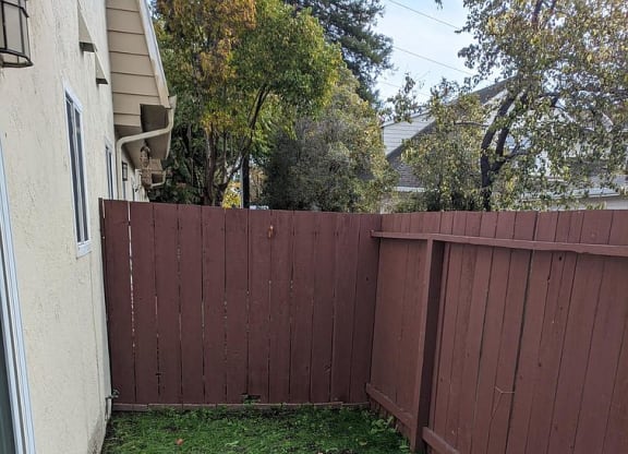 a backyard with a sidewalk and a fence