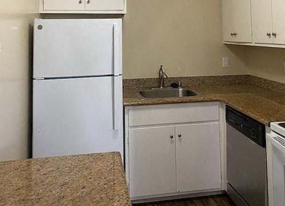 a kitchen with a white refrigerator and a sink
