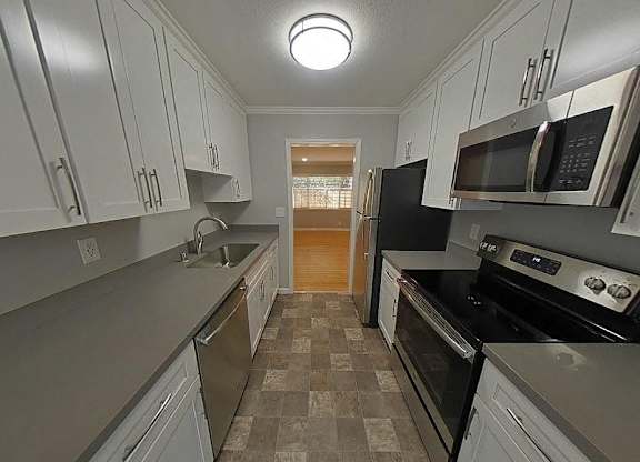 A kitchen with black appliances and white cabinets.