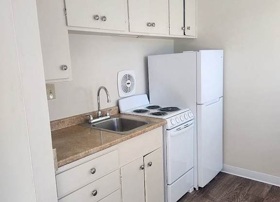 A kitchen with white appliances and cabinets.