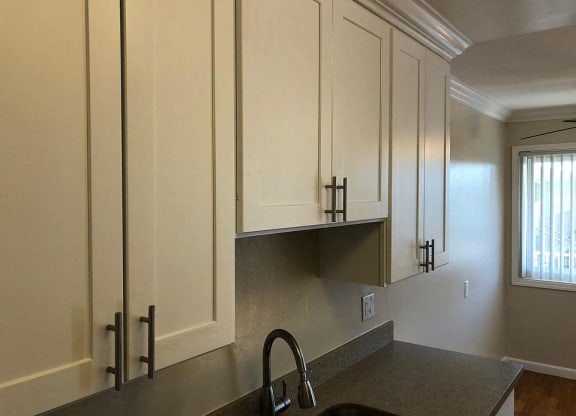 a kitchen with white cabinets and a sink