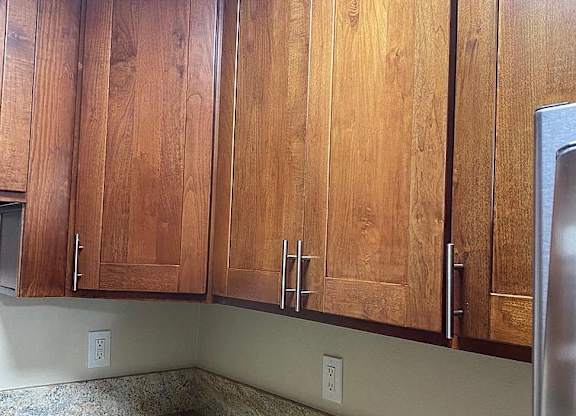 a kitchen with wooden cabinets and a granite counter top