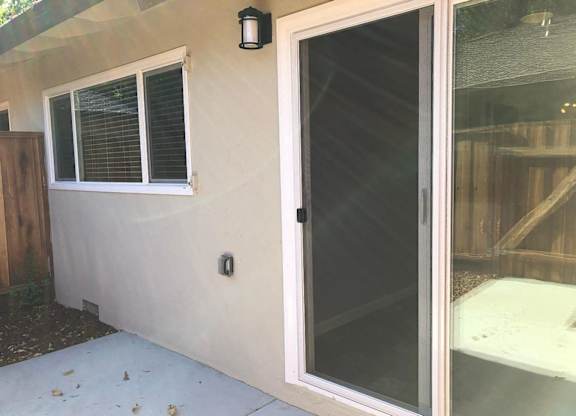 A white door with a black handle is on the side of a house.