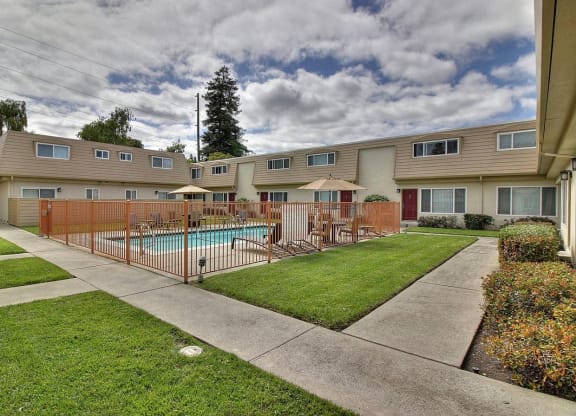 a yard with a swimming pool and a fence