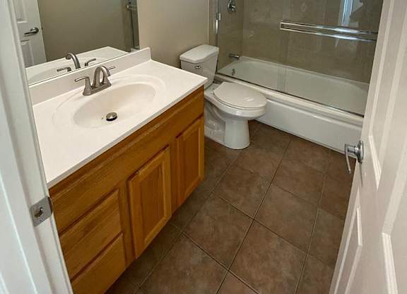 A bathroom with a sink, toilet, and shower.