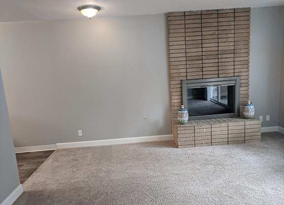 A living room with a fireplace and a flat screen TV.