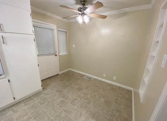 A room with a ceiling fan and tile flooring.