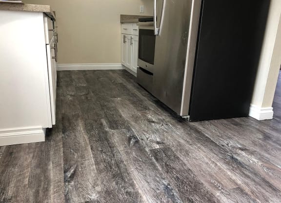 a kitchen with wood floors and a refrigerator