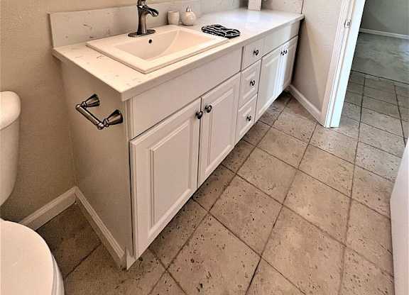 A bathroom with a sink, mirror, and toilet.