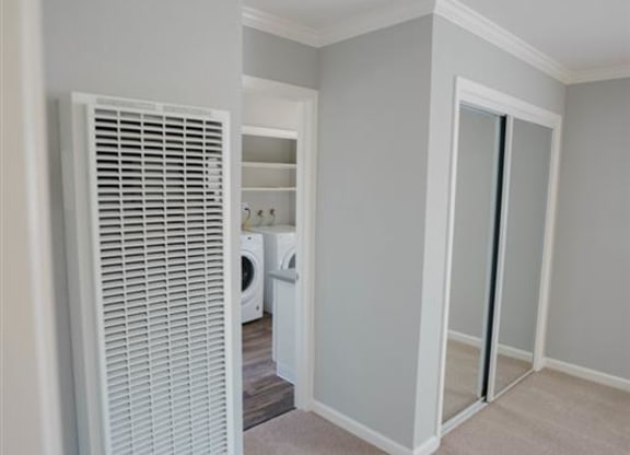 an empty room with a closet and a door to a bathroom