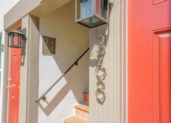 the front door of a unit with stairs and a light