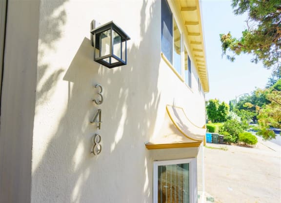the address on the side of a building with a lamp